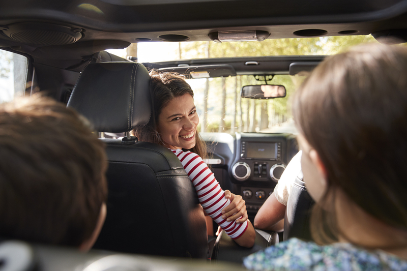 Happy family enjoying modern automotive technology and safety features in vehicle interior