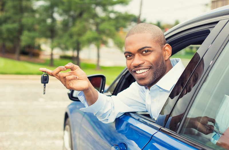 Happy student holding car keys showing successful vehicle ownership and independence