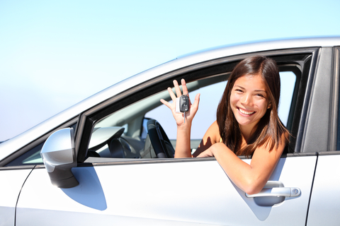 Happy teen driver holding car keys showing successful completion of driver safety training